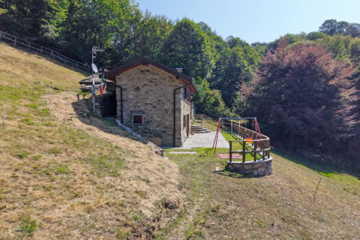 Stone house with a garden on a hillside in Menaggio